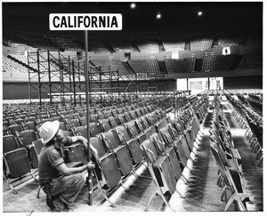 Workman placing California placard for 1960 Democratic National Convention, Los Angeles Memorial Sports Arena