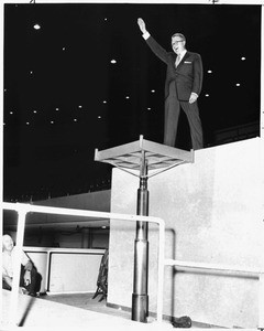 J. Leonard Reinsch tries out "presentation platform" elevator at Los Angeles Memorial Sports Arena, 1960