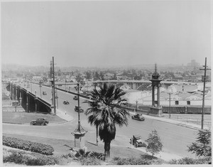 Traffic moving along the North Broadway Bridge, with a wrecked car in the foreground