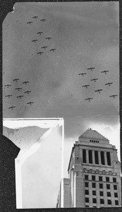 Twenty-seven huge army bombing planes soaring over Los Angeles City Hall in mock attack, 1932