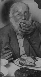 Old bearded man eating at Victoria Hall Mission, Los Angeles, 1924