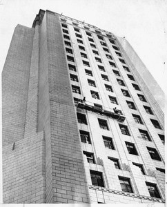 Hilmer Dolman (left) and Jack Croucher, high up on Spring Street facade of City Hall, are removing grimy smog, 1953