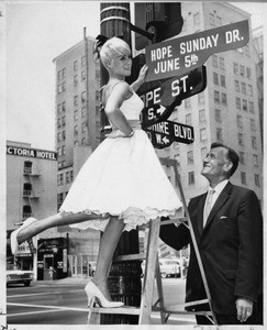 Hope Holiday & Arch Field change Hope Street sign, Los Angeles, 1960