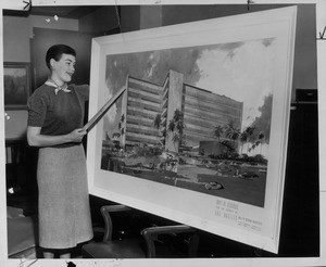 Judy Levstik pointing to a drawing of the future Hall of Records, 1957