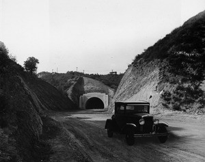 Automobile standing before Sepulveda Tunnel portal, 1930