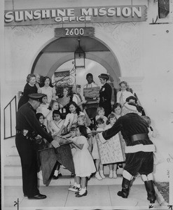 Toys are passed out to children in front of the Sunshine Mission, Los Angeles, 1958