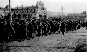 Prisoners being marched through Vladivostok, holding bread