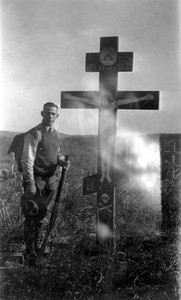 Mark Moody standing beside a Russian soldier's grave