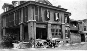 Alla Mae Moody and her chow dog, beside car and house in Shanghai