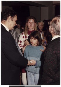 Mihael Kuzmič presenting a book to a baptized young girl