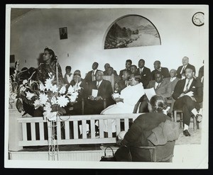 Beatrice Lott speaking to a group in a church