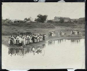 Unidentified group of people gathered at an outdoor baptism