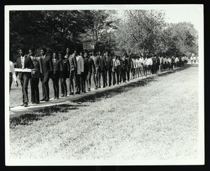 Long line of Saints Junior College faculty and female students marching single file