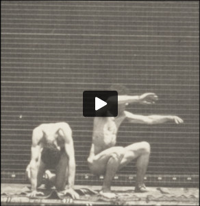 Nude man doing a handspring over another nude man's back