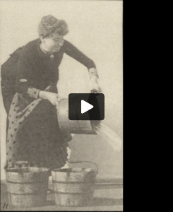 Draped woman emptying a bucket of water