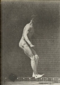 Nude man performing a running somersault