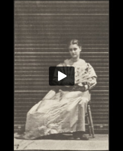 Woman in long dress sitting and flirting a fan