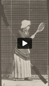 Woman in long dress playing lawn tennis