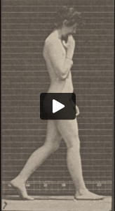 Nude woman walking keeping her right hand at her chin