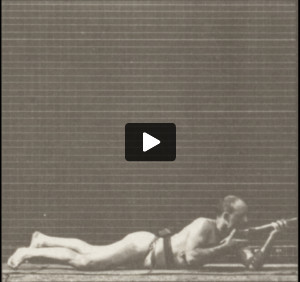 Man in pelvis cloth lying prone and firing a bayonet