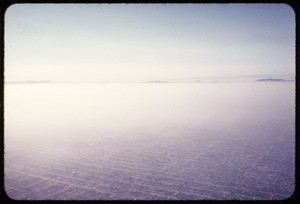 Aerial photograph of Los Angeles with haze and mountains in the distance, ca. 1973