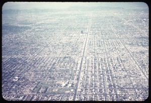 Aerial photograph of Los Angeles with haze and mountains in the distance, ca. 1973