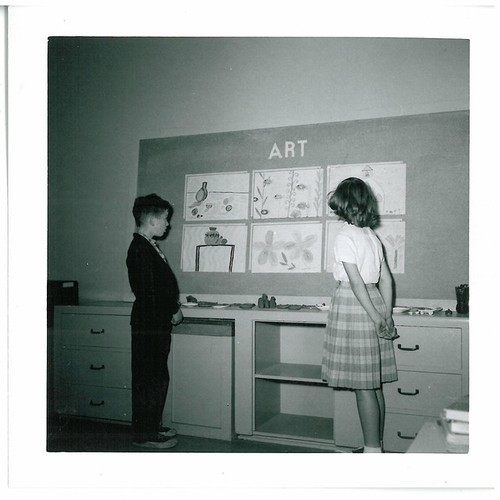 Elementary School Students Viewing Artwork on Bulletin Board in Classroom