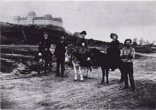 People and Mules Posing on Road in Front of Raymond Hotel