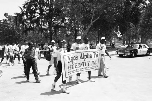 Kappa Alpha Psi members carrying a banner at the Black Family Reunion, Los Angeles, 1989