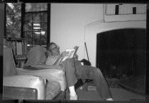 Man reading by library fireplace, 1985