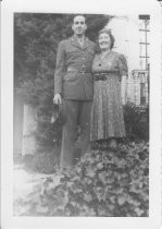 Mother with soldier standing on steps outside house, unknown