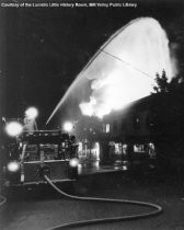 Firefighter Spraying a Fire Hose at Fire, 1984