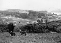 Nellie Armager with cocker spaniels standing at site of Enchanted Knolls, 1945