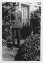 Soldier standing on steps outside house, unknown