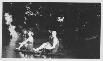 Bud Ortman and Jean McLarnonon on a raft in a creek, 1935