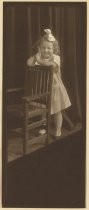 Ernestine Wood as a small child leaning on a chair, circa 1912
