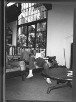 Man reading by library fireplace, 1985