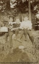 Three boys at train station, date unknown