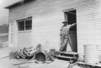 C. Russell Symes outside his plumbing shop, 1926