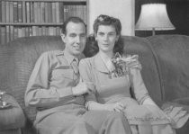 A couple sitting on sofa, man is a soldier, unknown