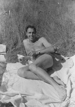 Man sitting on blanket on the ground, unknown