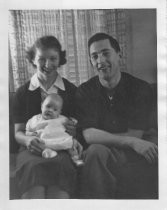 Cousin George and Mary holding baby inside house, unknown