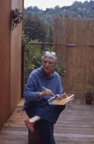 Ann O'Hanlon mixing paint outdoors looking sideways, 1977