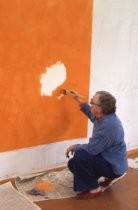 Ann O'Hanlon painting orange swath over white, 1977