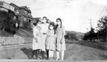 Four girls with masks on Buena Vista Avenue, circa 1918