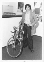 Richard Bernard, D.C., standing next to bike in office, 1980