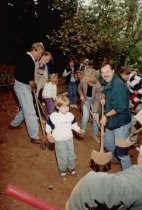 Adults and children digging with shovels at groudbreaking for library addition, 1997