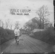 Man walking on dirt road, date unknown