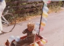 Photo of a boy in a wagon going to the July 4th Parade, 1974