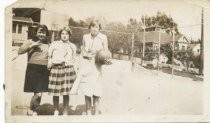 Three girls in Old Mill School school yard holding a basketball, 1955-1965